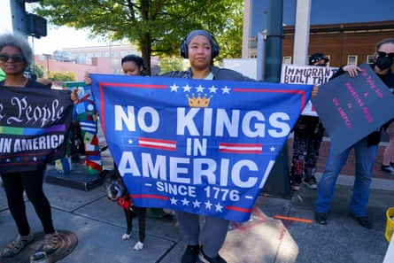 a woman holds a no kings flag