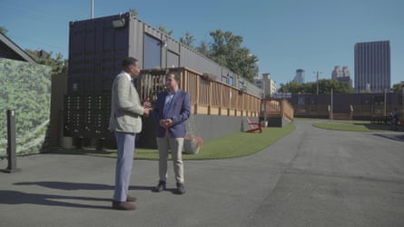 two men talk outside of a housing project