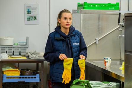 Dani Dyer holding on to a pair of yellow Marigold washing up gloves staring glumly into the distance