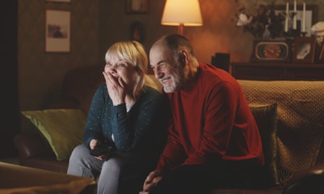 Couple laughing while watching TV