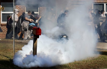Smoke rises from tear gas canisters fired by police .