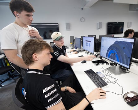 Three Oxford Brookes University students designing F1 cars on computer screens