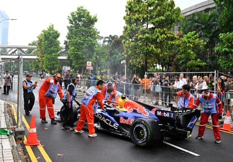 Marshals move the car of Red Bull's Isack Hadjar off the track after breaking down during the sprint race.