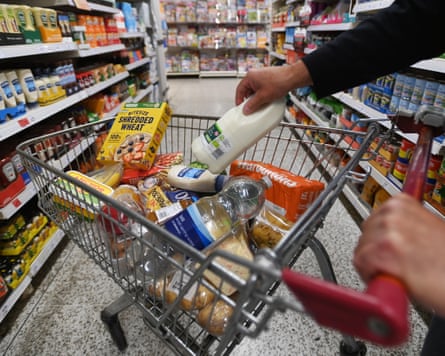 A shopper pushes a food trolley through a supermarket in central London