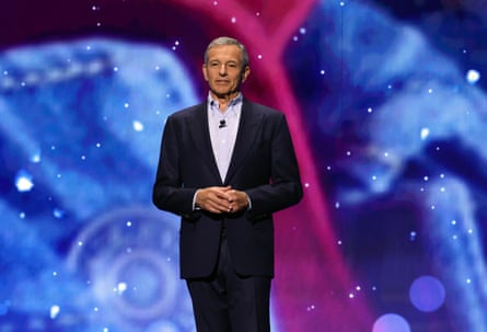 man wearing suit stands with hands clasped