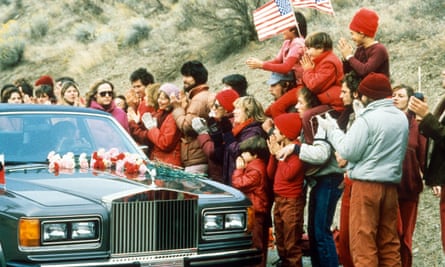 Rajneesh is greeted by followers as he enters the commune in a Rolls-Royce.