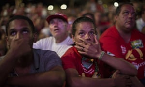 Pro-government demonstrators watch the vote count on a screen.