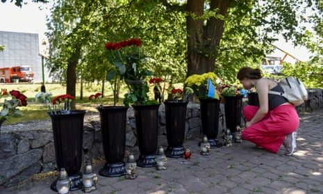 A woman lights a candle near the destroyed Amstor shopping mall in Kremenchuk, Ukraine.