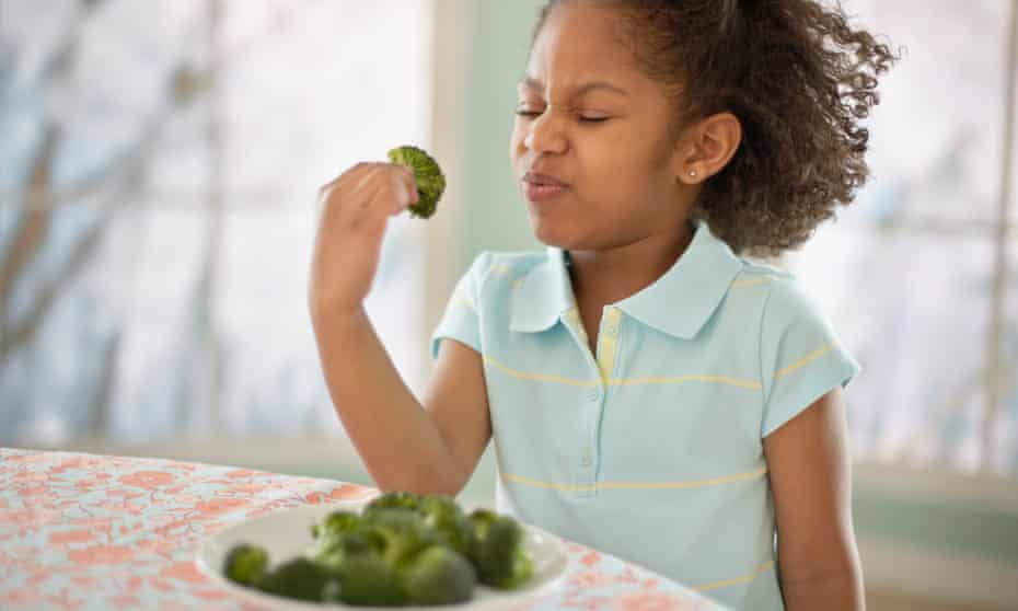 kid eats broccoli
