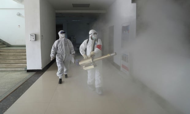 Volunteers in protective suits disinfect a residential compound in Wuhan on Sunday.
