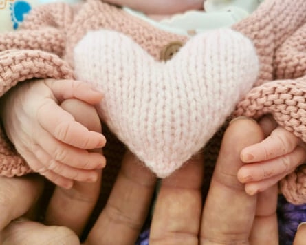 Baby’s hands on mother’s hands