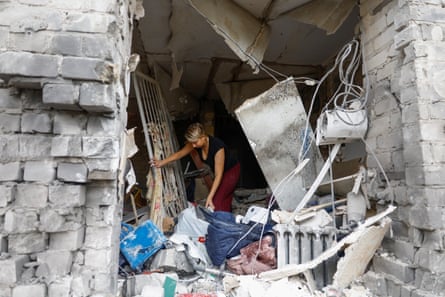 A woman collects belongings from her apartment damaged by a Russian missile strike
