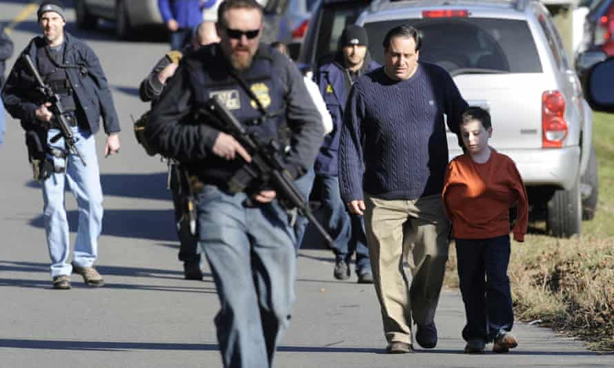 In this Dec. 14, 2012 file photo, parents leave a staging area after being reunited with their children following a shooting at the Sandy Hook Elementary School in Newtown, Conn.