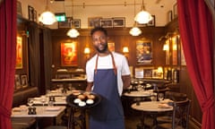 Josephine Bouchon, 315A Fulham Road, South Kensington, London, for Jay Rayner's restaurant review, OM, 07/03/2024. Sophia Evans for The Observer Waiter Tristan Thompson with small pots of butter and pork scratchings