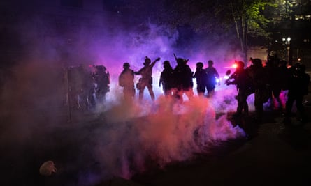 Federal agents fire teargas at protesters near the federal courthouse in Portland, Oregon, on 23 July.