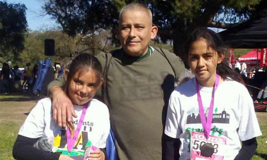 Rómulo Avelica-González with his daughters Yuleni, left, and Fatima, right, and their running medals.
