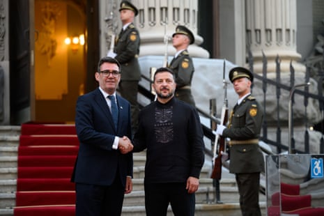 Andy Burnham and Volodymyr Zelenskyy shake hands as they pose for photos.