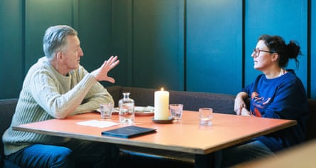 A man and woman facing each other across a restaurant table