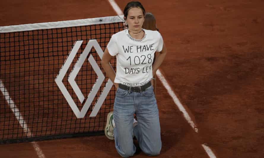 A protester ties herself to the net during the French Open semi-final between Casper Ruud and Marin Cilic