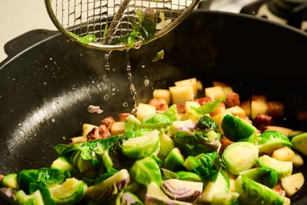 Boiled sprouts, kaiserfleisch and apples in a pan.
