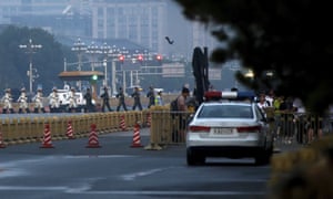 Policemen monitor people as a Chinese honour guard marches across a street after the daily flag raising ceremony at Tiananmen Square.