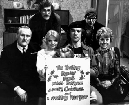 Cheryl Hall, seated second left, holding a poster with Robert Lindsay, and posing with the rest of the Citizen Smith cast