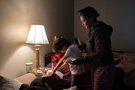 A woman getting her son ready for school in the dark