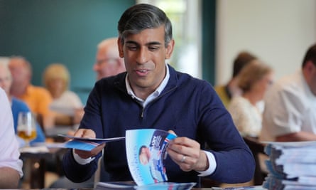 Rishi Sunak looking at election leaflets