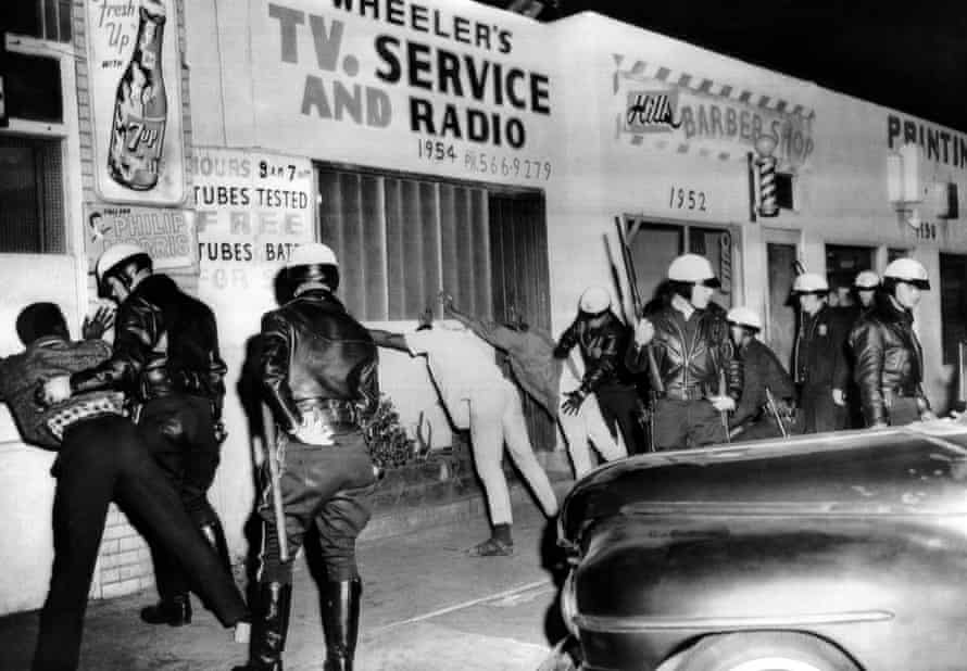 Police search African American youths in 1966.