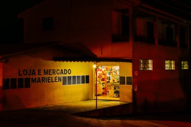 A small grocery lit up at night, November 2025