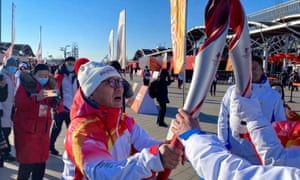 Luo Zhihuan passes the Olympic flame during the Olympic Torch launch ceremony in Beijing on Wednesday.