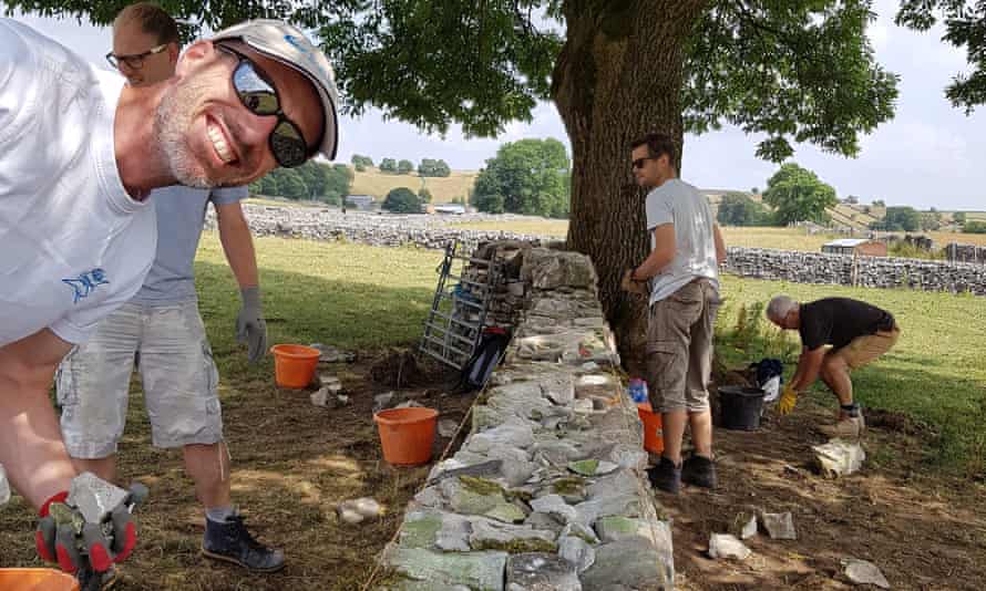 A group of people building a dry stone wall