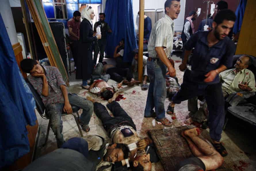 People wounded in Syria market attack receive treatment at a makeshift hospital in Douma.