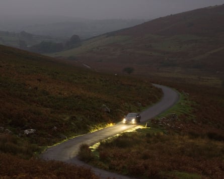 Car drives along a country road at night