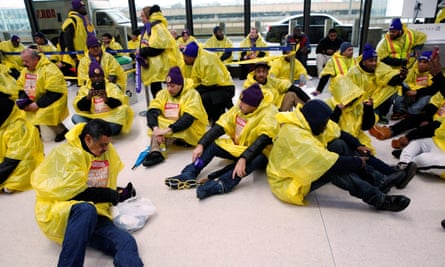 People sit in a terminal during a Fight for $15 wage protest at Newark International Airport in New Jersey Tuesday.