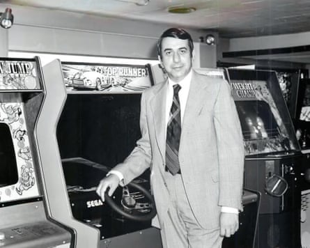 David Rosen stands next to arcade games machines