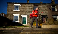 A postal worker on a delivery round in Summerseat, Greater Manchester
