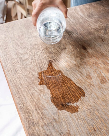 Person pouring water on wood