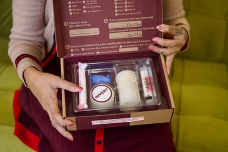 person holds a menstrual blood collection kit in a cardboard box