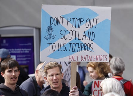 A man holding a sign that reads 'Don't pimp out Scotland to US tech bros' at the anti-datacentre protest in Edinburgh.