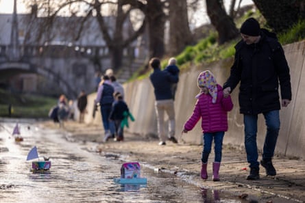 A girl walks with her father next to their homemade miniature boats floating down the stream during an event to celebrate the arrival of spring in Ljubljana in March.
