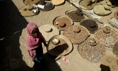 A girl walks past spices displayed for sale in a market in Mao, in the Kanem region of Chad