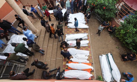 The bodies of Palestinians killed during Israeli strikes are laid out in the court yard.