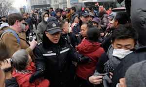 Police officers push away supporters of rights lawyer Pu Zhiqiang and foreign journalists near the Beijing Second Intermediate People’s Court in Beijing on Monday.