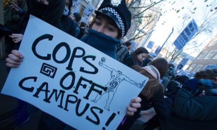 A protester holds a sign reading 'cops off campus'