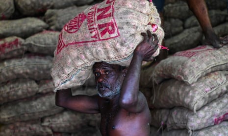 A labourer carries a sack of onions at a market in Colombo. The IMF has approved a $2.9bn bailout for the island nation.