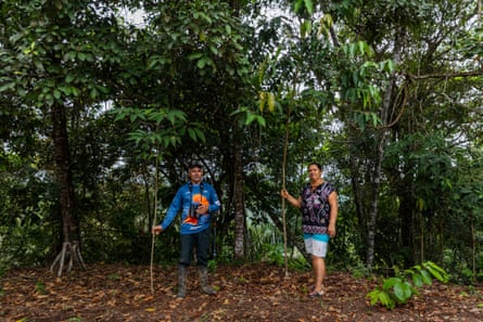 A man and a woman standing in front of trees