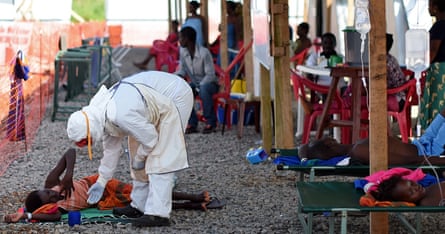 A nurse in full protective equipment checks on a patient at the Kenama Ebola treatment centre in 2014