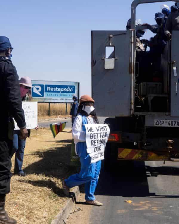 Tsitsi Dangarembga (centre) and a colleague Julie Barnes hold placards as they are arrested during an anti-corruption protest in July 2020 in Harare.