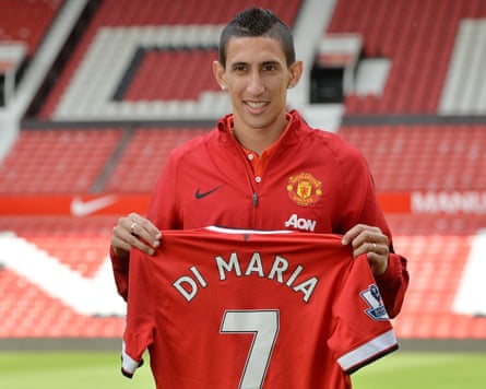 Ángel Di María holds up his new Manchester United shirt in 2014 with the number seven on the back, on the pitch at Old Trafford